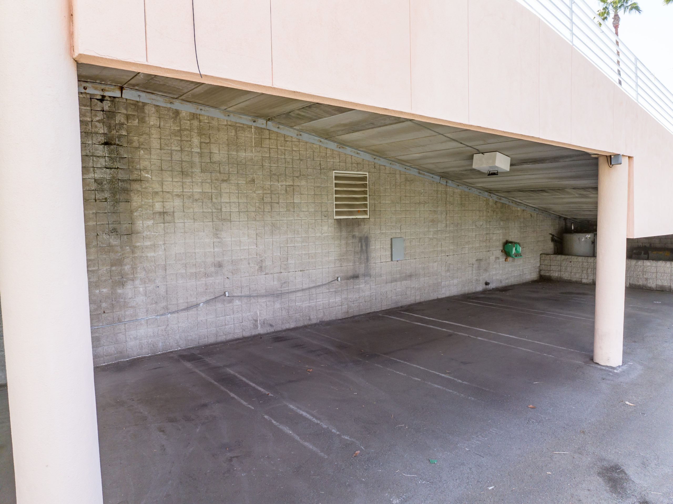 under a car ramp at an abandoned car dealership