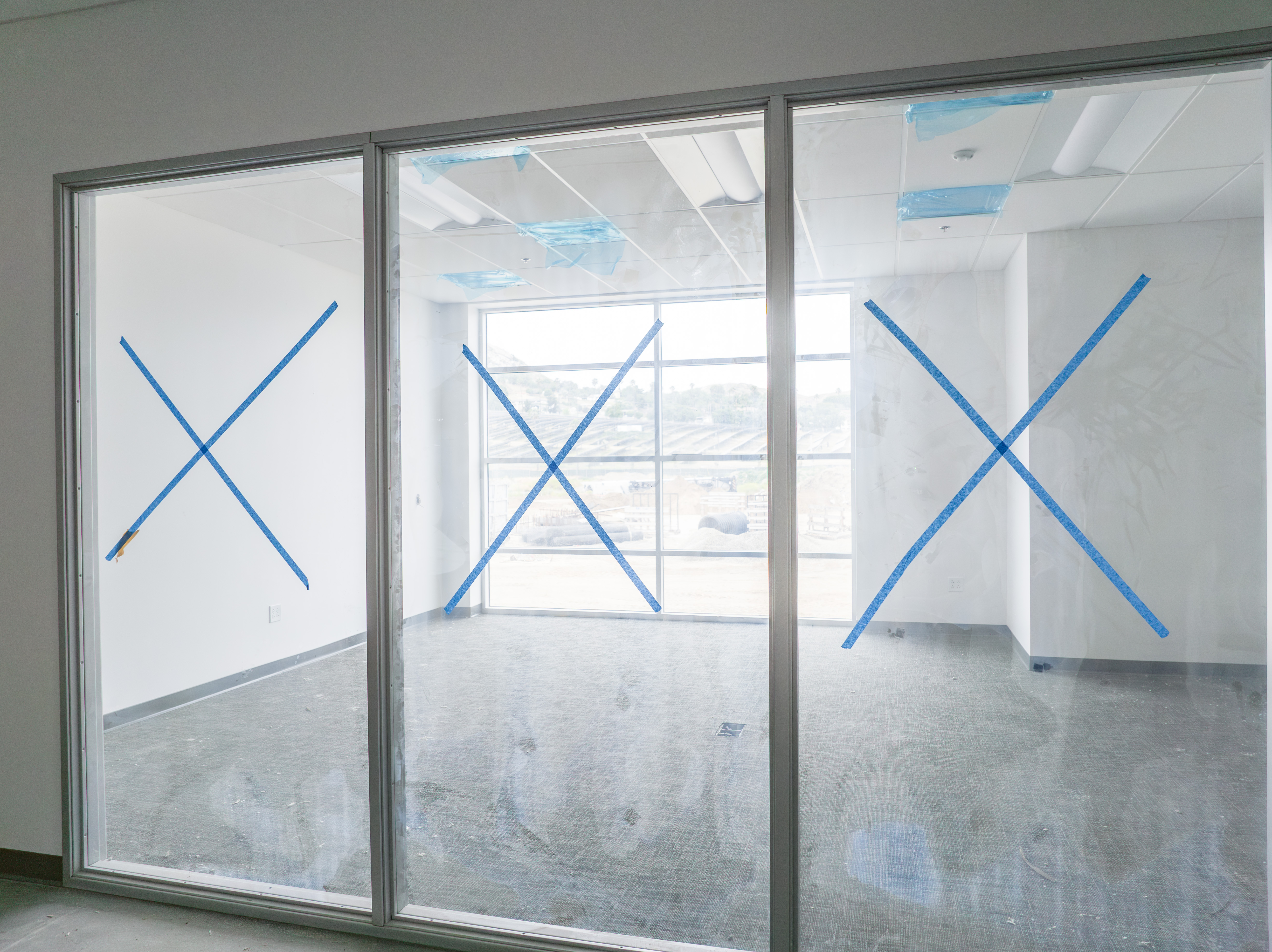 glass walls for an office with tape x's on them