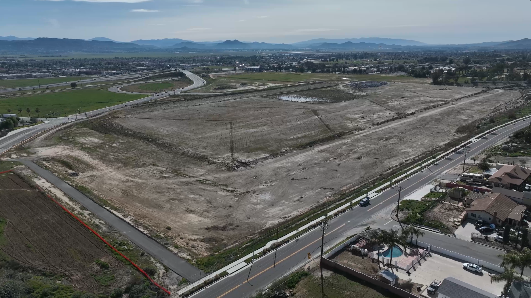 construction site shot from above with freeway in frame