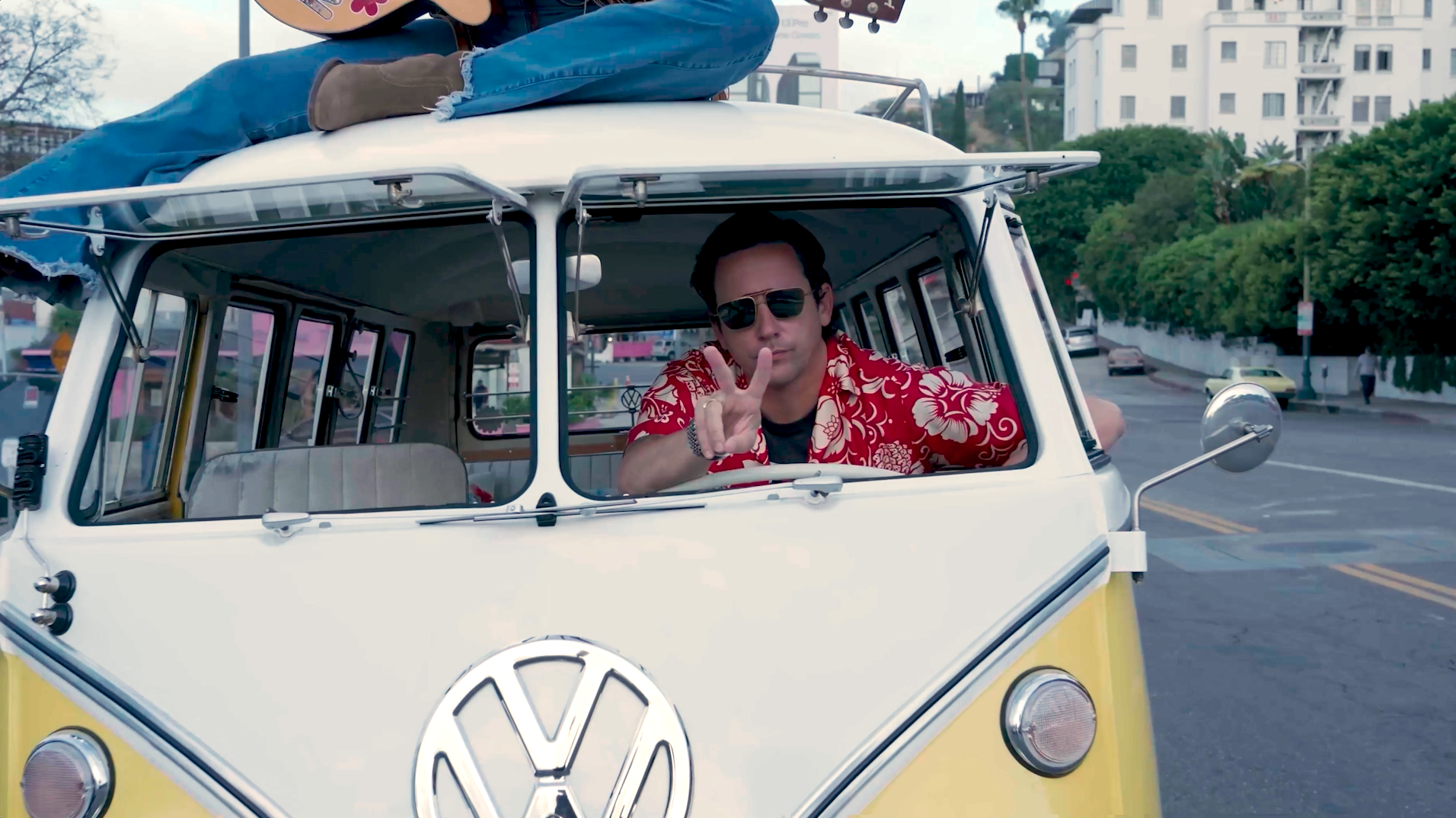 man giving peace sign inside VW van