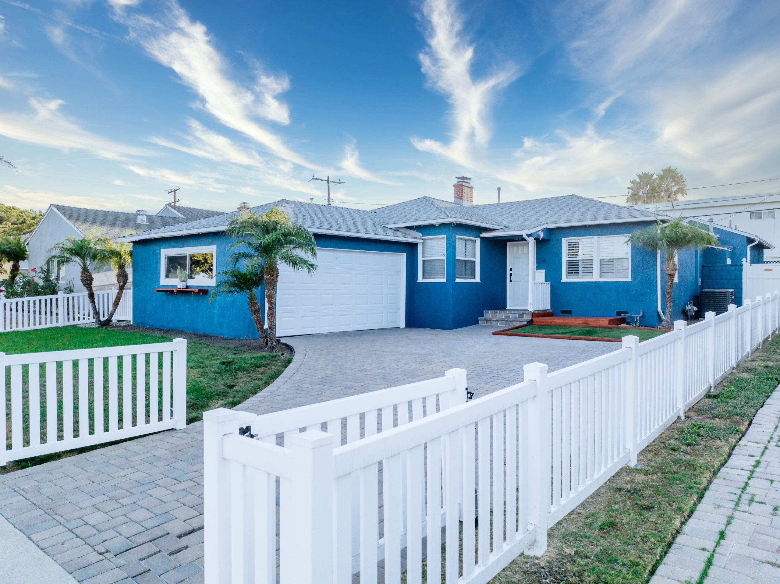 drone photo of the front of a house for sale with clouds in the background