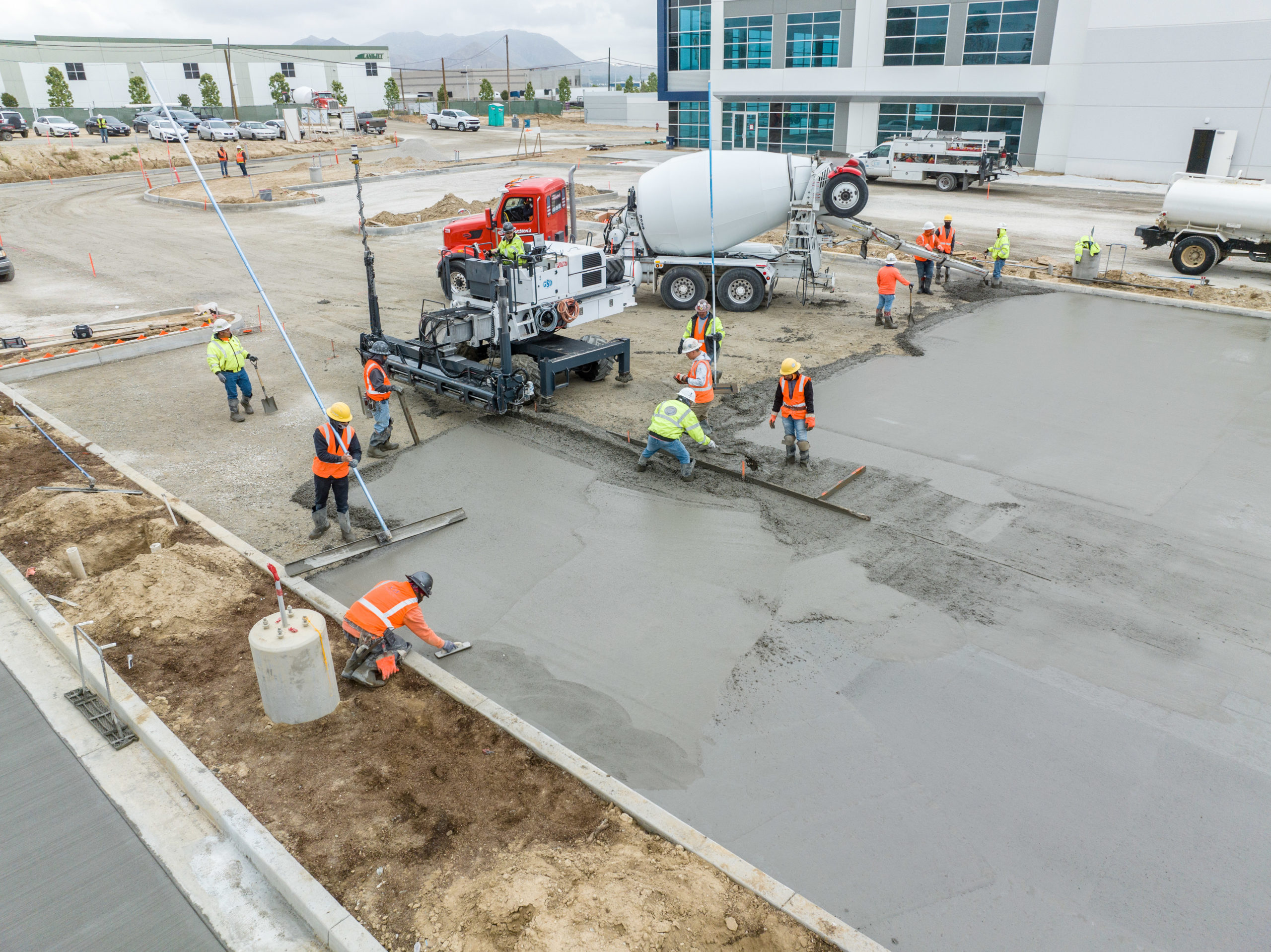 workers pouring concrete on parking area