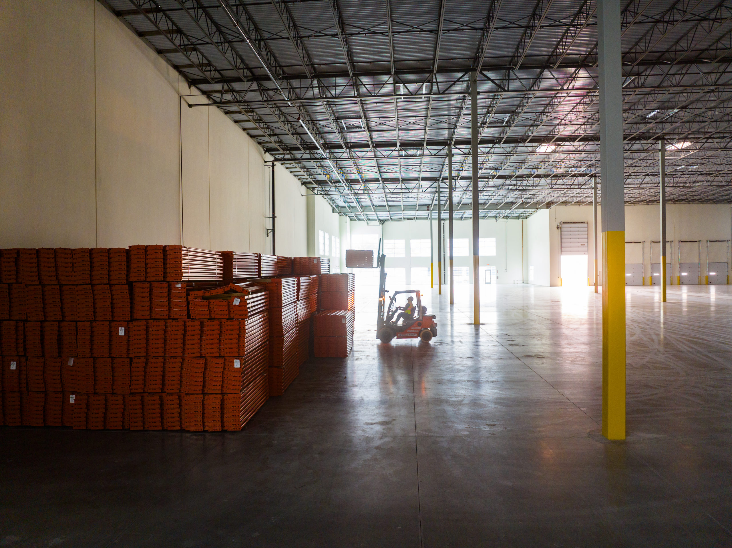 forklift backlit by sun shinning thru windows at Agua Mansa construction site